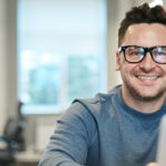 Lächelnder Mann mit Brille arbeitet am Laptop. eR Hack Nr. 3. erecruiter, Bewerbermanagement