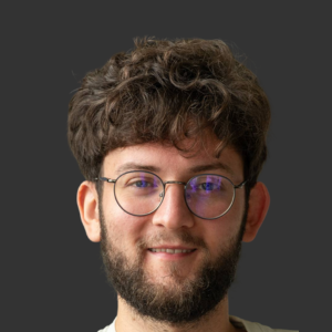 Porträtfoto eines lächelnden Mannes mit lockigem braunem Haar und Brille - eRecruiter