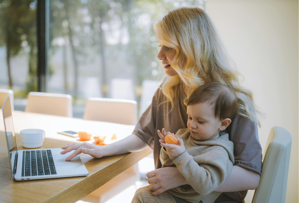 Frau arbeitet mit Baby am Laptop und balanciert Vereinbarkeit von Familie und Beruf; Flexible Arbeitszeiten verbinden Familienalltag und Beruf - eRecruiter